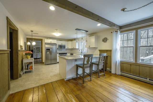 127 Skunk Misery Rd, Haddam, CT 06441 - kitchen featuring appliances with stainless steel finishes, light wood-type flooring, a peninsula, white cabinetry, and a kitchen breakfast bar