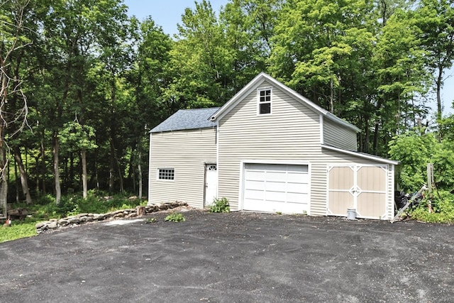 971 New Litchfield St, Torrington, CT 06790 - garage with driveway and view of wooded area