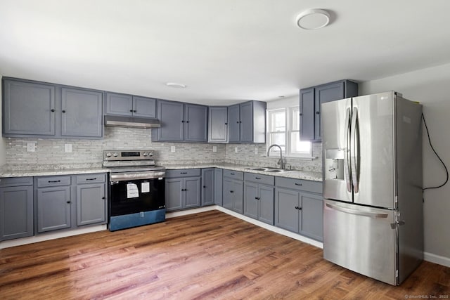 971 New Litchfield St, Torrington, CT 06790 - kitchen featuring appliances with stainless steel finishes, under cabinet range hood, gray cabinetry, and backsplash