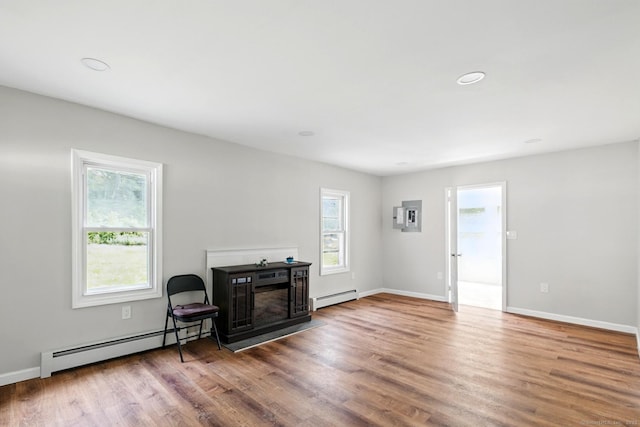 971 New Litchfield St, Torrington, CT 06790 - living room featuring a baseboard heating unit, a fireplace, and wood finished floors