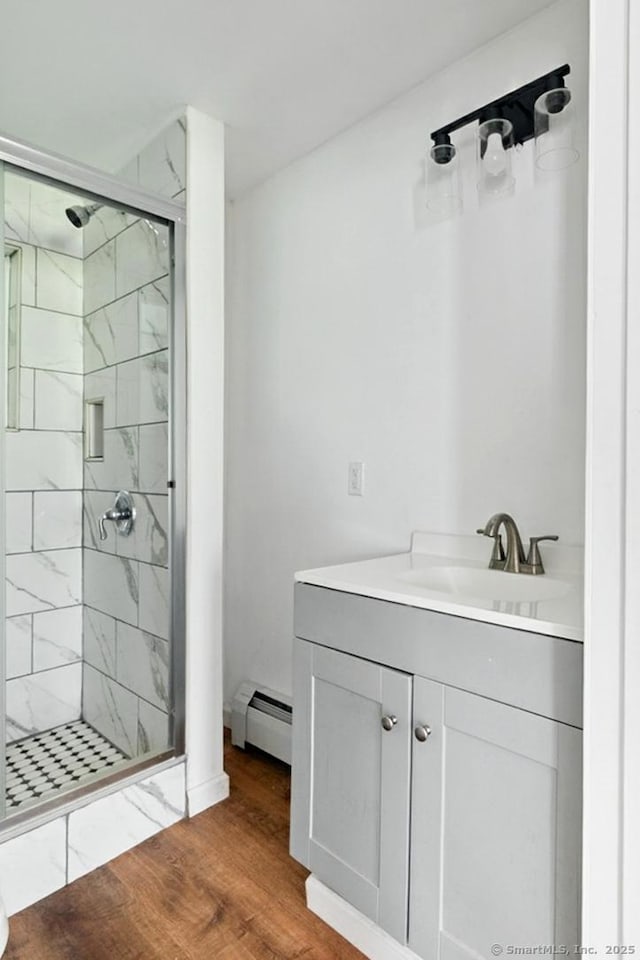971 New Litchfield St, Torrington, CT 06790 - bathroom featuring a baseboard heating unit, a shower stall, vanity, and wood finished floors