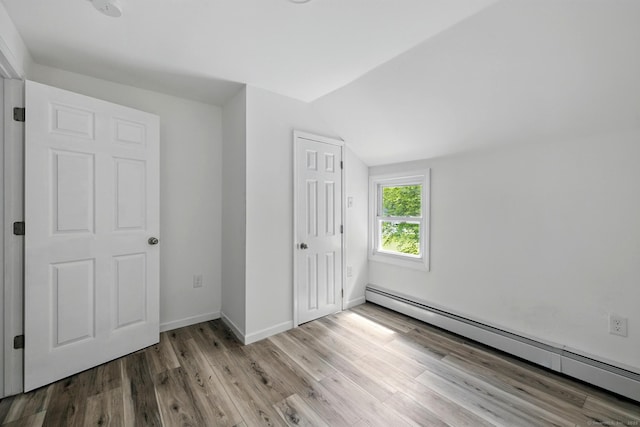 971 New Litchfield St, Torrington, CT 06790 - unfurnished bedroom with a baseboard radiator, vaulted ceiling, wood finished floors, and a closet