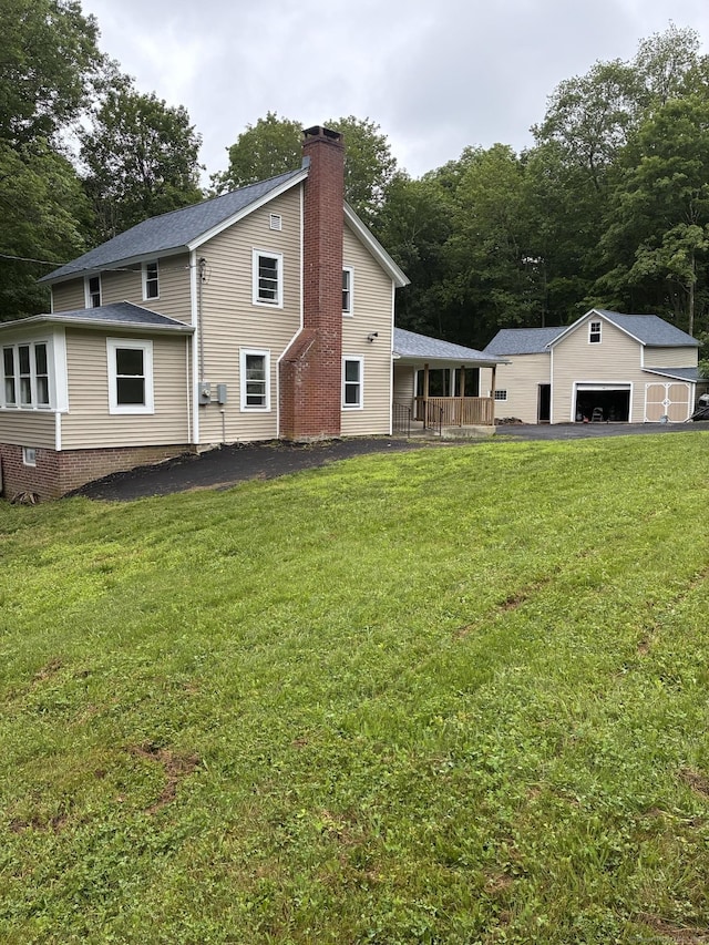 971 New Litchfield St, Torrington, CT 06790 - back of house featuring a chimney, a lawn, an outdoor structure, and a garage