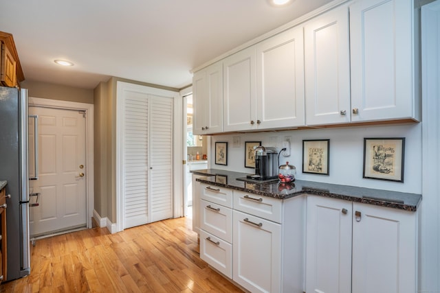 251 Ridgewood Rd, West Hartford, CT 06107 - kitchen featuring freestanding refrigerator, white cabinetry, light wood-style floors, dark stone countertops, and recessed lighting