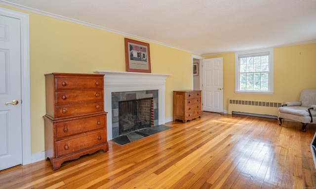 251 Ridgewood Rd, West Hartford, CT 06107 - living room featuring radiator heating unit, light wood finished floors, a fireplace with flush hearth, and ornamental molding