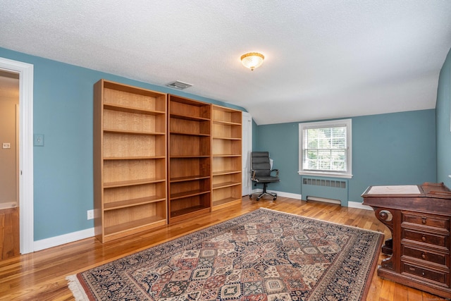 251 Ridgewood Rd, West Hartford, CT 06107 - office area with radiator heating unit, light wood-style flooring, vaulted ceiling, and a textured ceiling