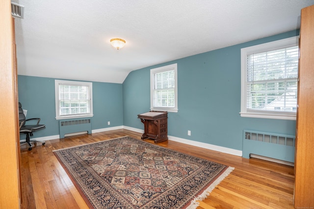 251 Ridgewood Rd, West Hartford, CT 06107 - home office with radiator heating unit, wood finished floors, lofted ceiling, plenty of natural light, and a textured ceiling