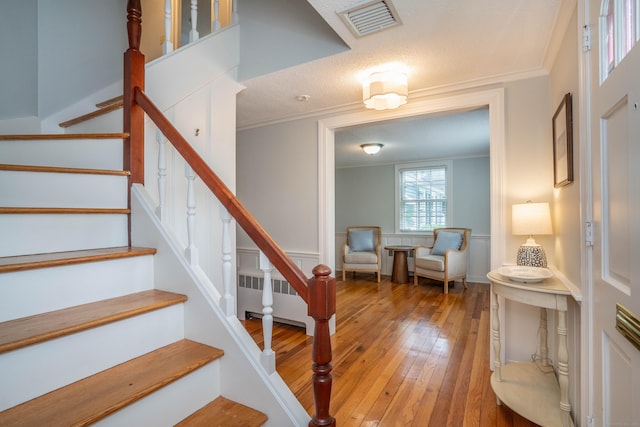 251 Ridgewood Rd, West Hartford, CT 06107 - stairs with radiator heating unit, hardwood / wood-style floors, and ornamental molding