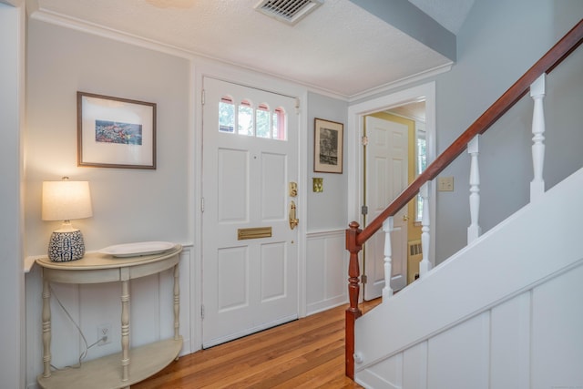 251 Ridgewood Rd, West Hartford, CT 06107 - foyer with light wood-style floors, stairs, crown molding, and a wainscoted wall
