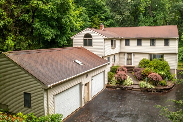 116 Bellridge Rd, Glastonbury, CT 06033 - colonial house featuring a chimney, a shingled roof, driveway, and an attached garage