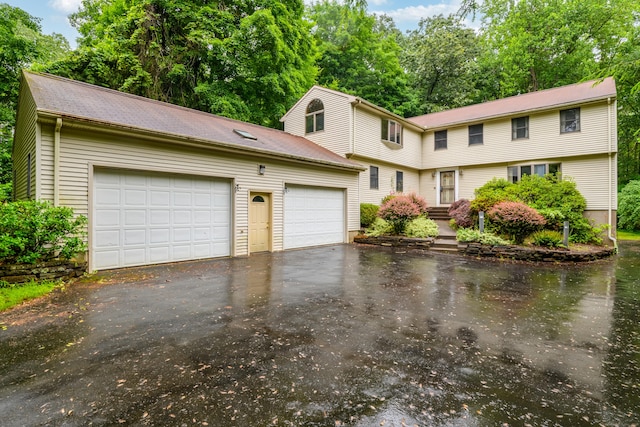 116 Bellridge Rd, Glastonbury, CT 06033 - colonial-style house featuring asphalt driveway, a garage, an outbuilding, and view of wooded area