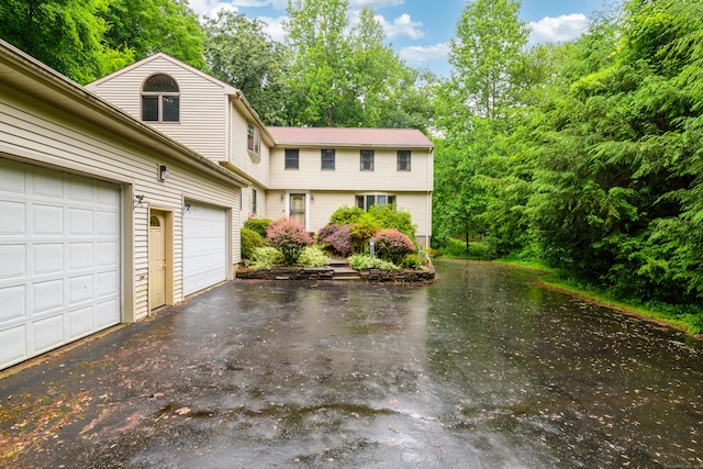 116 Bellridge Rd, Glastonbury, CT 06033 - colonial-style house with driveway, a garage, and view of wooded area