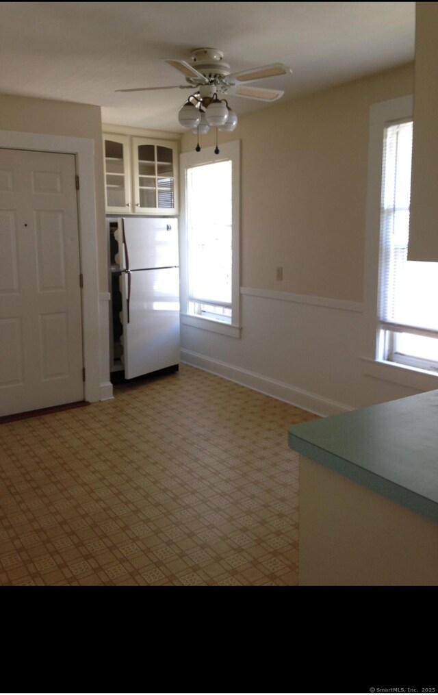 20 George St, Bristol, CT 06010 - kitchen with freestanding refrigerator, a ceiling fan, light carpet, and glass insert cabinets