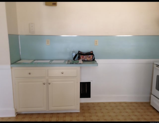 20 George St, Bristol, CT 06010 - kitchen featuring light countertops, white cabinetry, and light floors