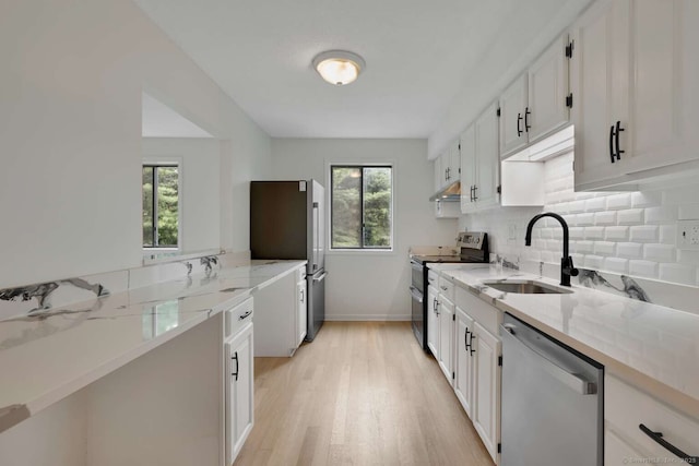 25 Florence Rd Unit 84, Branford, CT 06405 - kitchen featuring appliances with stainless steel finishes, light wood-type flooring, tasteful backsplash, under cabinet range hood, and white cabinets