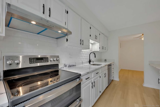 25 Florence Rd Unit 84, Branford, CT 06405 - kitchen with stainless steel appliances, under cabinet range hood, light wood-type flooring, backsplash, and white cabinets