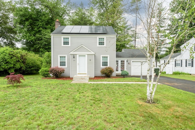 193 Oak St, East Hartford, CT 06118 - view of front of property with asphalt driveway, a garage, a chimney, and a front lawn