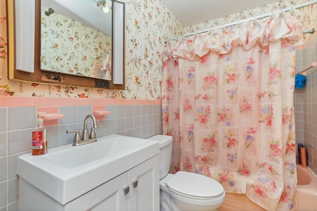 97 Travis Dr, Bridgeport, CT 06606 - bathroom with wallpapered walls, tile walls, vanity, shower / bathtub combination with curtain, and wainscoting