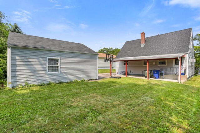 97 Travis Dr, Bridgeport, CT 06606 - rear view of property featuring a patio area, a chimney, a lawn, and roof with shingles