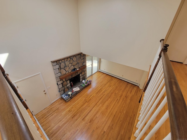 12 Enrico Rd, Bolton, CT 06043 - living room with baseboard heating, a high ceiling, wood finished floors, a fireplace, and stairs