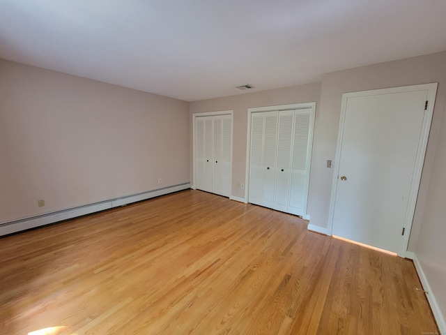12 Enrico Rd, Bolton, CT 06043 - unfurnished bedroom featuring baseboard heating, two closets, and light wood-type flooring