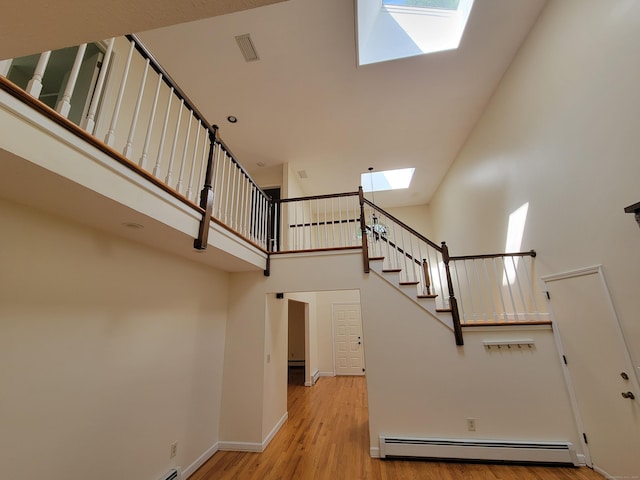 12 Enrico Rd, Bolton, CT 06043 - stairs with a skylight, a baseboard radiator, a high ceiling, and wood finished floors