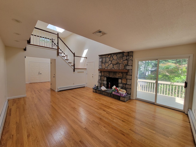 12 Enrico Rd, Bolton, CT 06043 - unfurnished living room featuring a skylight, baseboard heating, stairs, wood finished floors, and a fireplace