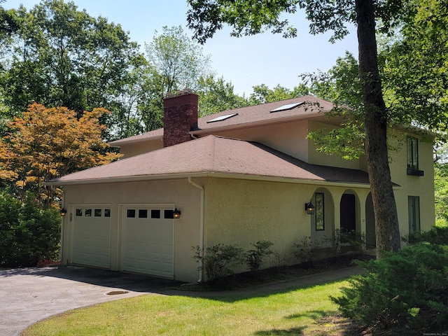 12 Enrico Rd, Bolton, CT 06043 - view of side of home featuring stucco siding, a chimney, a garage, and driveway