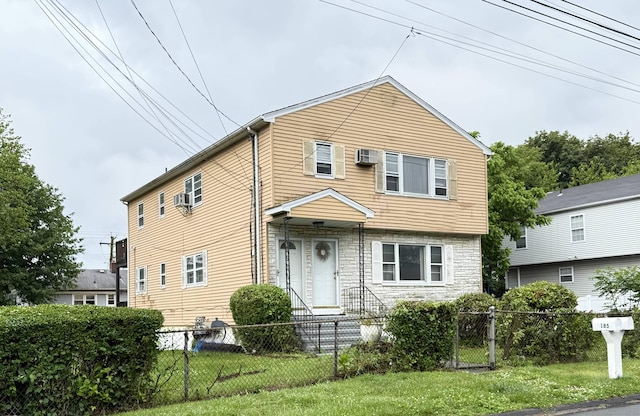 view of front of home featuring a fenced front yard, stone siding, and an AC wall unit