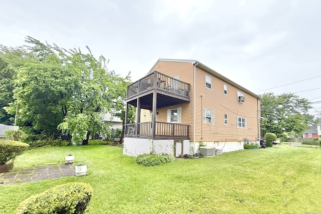 back of house featuring a lawn and a balcony