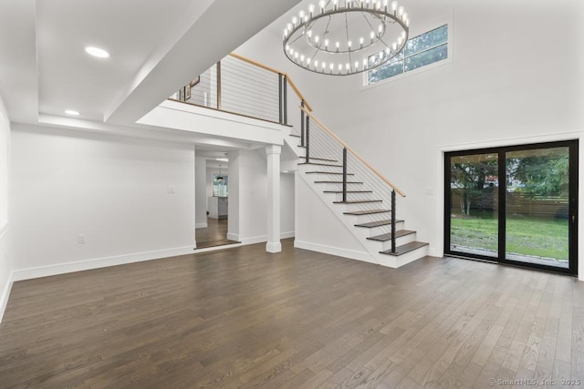 1207 Stillson Rd, Fairfield, CT 06824 - unfurnished living room with stairs, plenty of natural light, wood finished floors, a high ceiling, and a chandelier