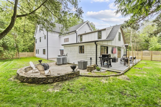 1207 Stillson Rd, Fairfield, CT 06824 - back of property with board and batten siding, a wooden deck, a fenced backyard, roof with shingles, and an outdoor fire pit