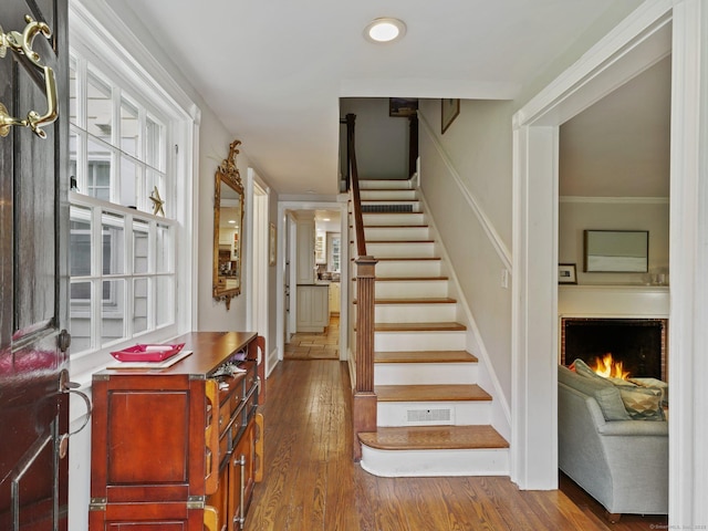 33 Great Pasture Rd, Redding, CT 06896 - stairway featuring wood finished floors, a warm lit fireplace, recessed lighting, and ornamental molding