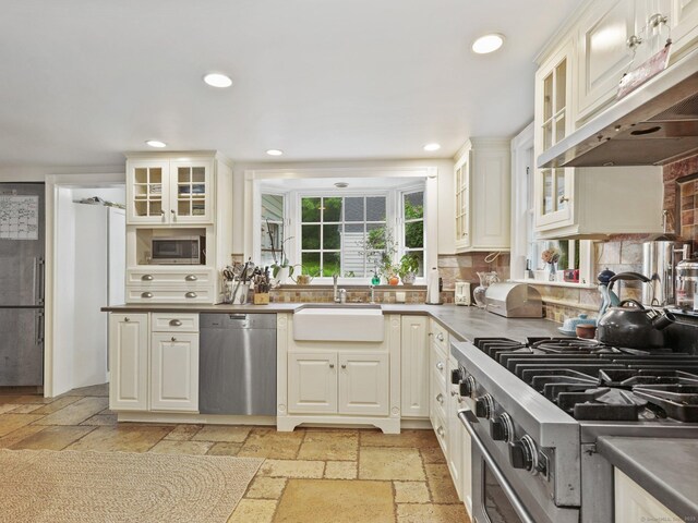 33 Great Pasture Rd, Redding, CT 06896 - kitchen featuring appliances with stainless steel finishes, under cabinet range hood, stone tile floors, recessed lighting, and decorative backsplash