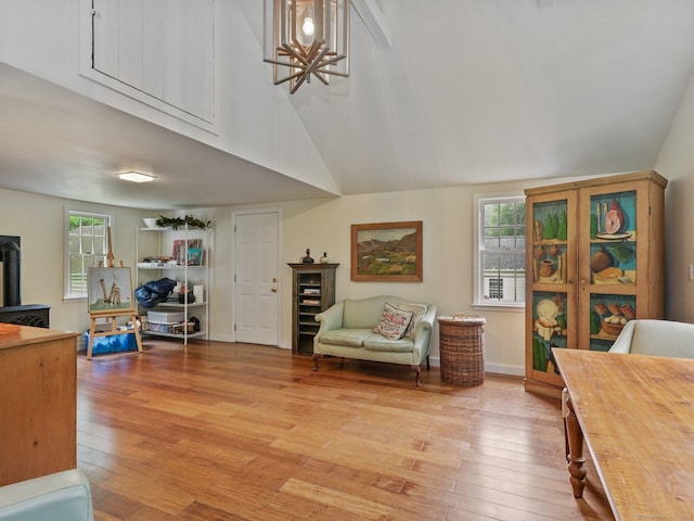 33 Great Pasture Rd, Redding, CT 06896 - living room with light wood finished floors, healthy amount of natural light, a chandelier, high vaulted ceiling, and a wood stove