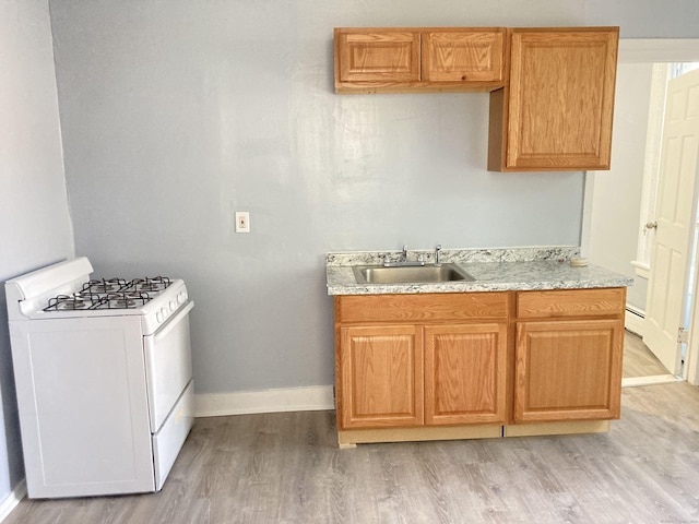 34 Park St, Bridgeport, CT 06608 - kitchen featuring white range with gas stovetop, light wood-style flooring, and a baseboard radiator
