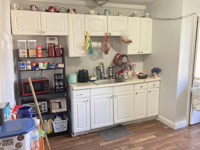 34 Park St, Bridgeport, CT 06608 - kitchen with black microwave, light countertops, dark wood-style floors, and white cabinetry