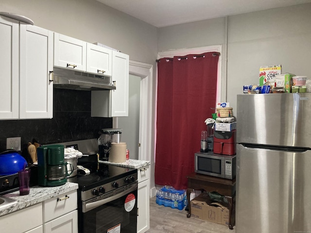 34 Park St, Bridgeport, CT 06608 - kitchen with appliances with stainless steel finishes, under cabinet range hood, white cabinetry, and light wood finished floors