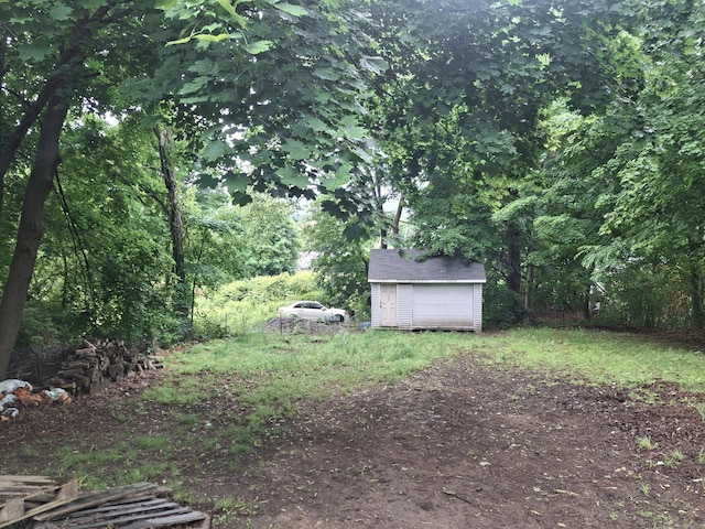 138 Harwinton Ave, Torrington, CT 06790 - view of yard with a storage shed, a garage, and a view of trees