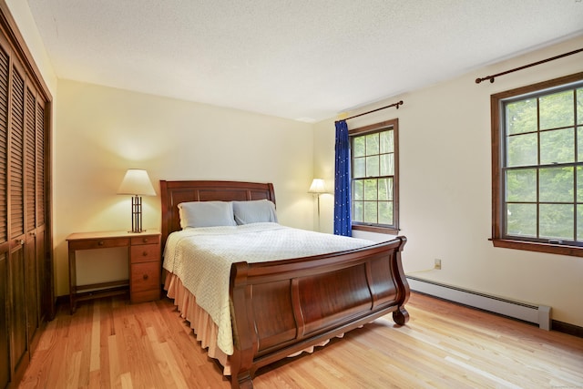 270 N Bride Brook Rd, East Lyme, CT 06333 - bedroom featuring a baseboard radiator, light wood-style flooring, multiple windows, and a closet