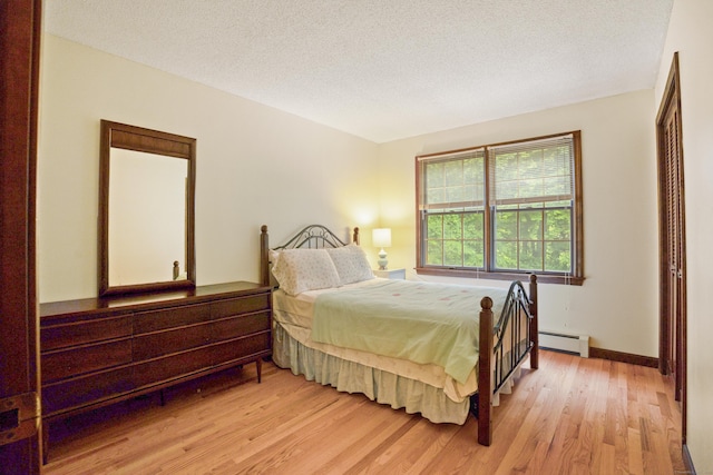 270 N Bride Brook Rd, East Lyme, CT 06333 - bedroom with light wood-style flooring, baseboard heating, a textured ceiling, and a closet