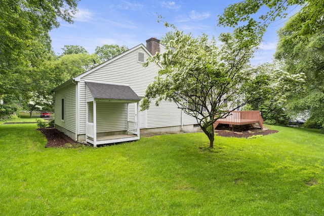 270 N Bride Brook Rd, East Lyme, CT 06333 - back of house with a chimney, a wooden deck, a yard, and roof with shingles
