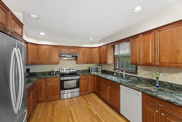 270 N Bride Brook Rd, East Lyme, CT 06333 - kitchen with appliances with stainless steel finishes, under cabinet range hood, light wood-style flooring, brown cabinetry, and recessed lighting