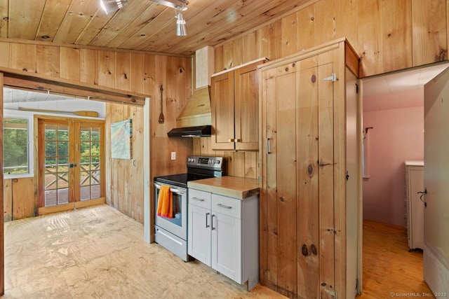 57 River Rd, Clinton, CT 06413 - kitchen with electric range, french doors, wood ceiling, wood walls, and white cabinets