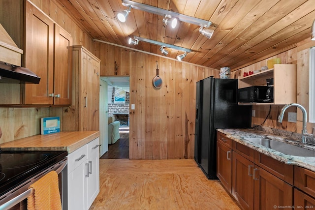 57 River Rd, Clinton, CT 06413 - kitchen with black appliances, rail lighting, wood walls, ventilation hood, and light wood finished floors
