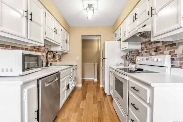 304 Foxwood Ln Unit 304, Milford, CT 06461 - kitchen with white appliances, under cabinet range hood, decorative backsplash, white cabinets, and light countertops
