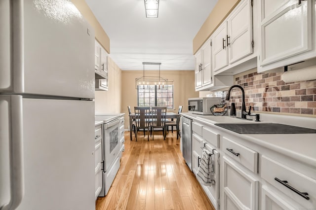 304 Foxwood Ln Unit 304, Milford, CT 06461 - kitchen featuring white appliances, light countertops, white cabinets, decorative backsplash, and light wood-type flooring