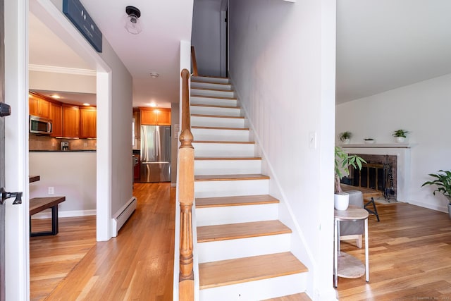 39 Aspen Mill Rd, Ridgefield, CT 06877 - staircase with baseboard heating, wood finished floors, and a brick fireplace