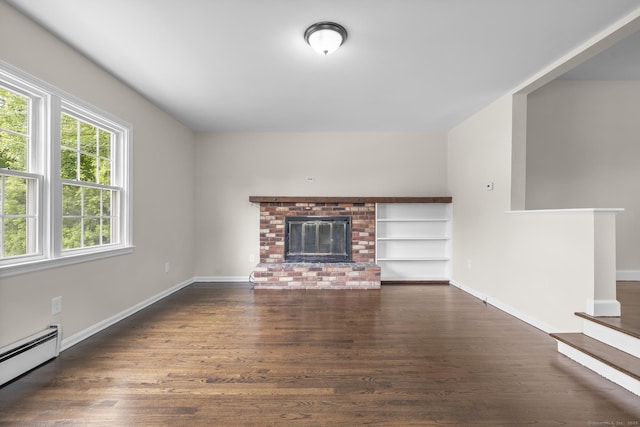 5 Skiff Pkwy, North Haven, CT 06473 - unfurnished living room with baseboard heating, wood finished floors, a brick fireplace, and built in features