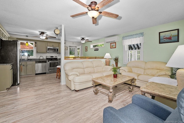 47 Little Bungee Hill Rd, Woodstock, CT 06282 - living room featuring a ceiling fan, light wood-style flooring, a wall mounted AC, and a textured ceiling